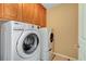 Bright laundry room features full size washer and dryer with built in cabinets above at 11356 Belmont Lake Dr # 103, Las Vegas, NV 89135