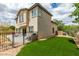 Fenced backyard featuring a cozy patio area with artificial grass for easy maintenance at 11769 Via Vera Cruz Ct, Las Vegas, NV 89138