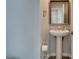 Charming pedestal sink with framed mirror and modern fixtures in this well-lit bathroom at 11769 Via Vera Cruz Ct, Las Vegas, NV 89138