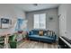 Bright bedroom featuring a cozy blue sofa, light wood floors, and ample natural light from the window at 11769 Via Vera Cruz Ct, Las Vegas, NV 89138