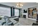 Cozy living room featuring a decorative fireplace, modern light fixture, and comfortable gray sofa at 11769 Via Vera Cruz Ct, Las Vegas, NV 89138