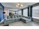 Bright living room featuring a large sectional sofa, modern light fixture, and open floor plan at 11769 Via Vera Cruz Ct, Las Vegas, NV 89138
