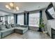 Open-concept living room featuring a modern light fixture and comfortable gray sofa at 11769 Via Vera Cruz Ct, Las Vegas, NV 89138
