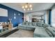 Comfortable living room with a large sectional, stylish lighting, and an accent wall at 11769 Via Vera Cruz Ct, Las Vegas, NV 89138