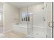 Bright bathroom with a soaking tub and walk-in shower featuring neutral walls and wood-look tile flooring at 11843 Cogoleto Ave, Las Vegas, NV 89138