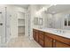 Bright bathroom with dual sinks, a walk-in shower and a walk-in closet at 11843 Cogoleto Ave, Las Vegas, NV 89138