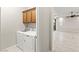 Laundry room with appliances, light-colored tile flooring and wood cabinets at 11843 Cogoleto Ave, Las Vegas, NV 89138