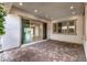 Covered outdoor patio with brick flooring and views of the spacious living area at 11843 Cogoleto Ave, Las Vegas, NV 89138