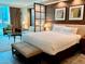 Bright bedroom with a large bed, seating area, and city views at 125 E Harmon Ave # 1003, Las Vegas, NV 89109