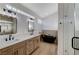 This bathroom features a double vanity with black hardware, and a standalone tub with wood accents at 1317 Fox Acres Dr, Las Vegas, NV 89134