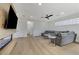 Contemporary living room featuring a gray sectional sofa, modern fan, and sleek fireplace, perfect for relaxation at 1317 Fox Acres Dr, Las Vegas, NV 89134