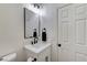 Clean powder room with a white vanity, black fixtures, and a sleek mirror for a modern touch at 1317 Fox Acres Dr, Las Vegas, NV 89134