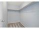 Simple walk-in closet with painted blue walls, grey carpet, and wooden rails for hanging clothes at 1329 Jewelstone Cir, Henderson, NV 89012