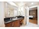 Bathroom with vanity, large mirror and a doorway leading to a bedroom with curtains at 145 Harmon Ave # 1021, Las Vegas, NV 89109