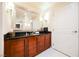 Bathroom features a wooden vanity with granite countertop and large mirror at 145 Harmon Ave # 1021, Las Vegas, NV 89109