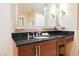 Close-up of bathroom vanity featuring granite countertop, mirror, and makeup stool at 145 Harmon Ave # 1021, Las Vegas, NV 89109