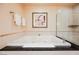 Elegant bathroom highlighting a soaking tub with black countertop and modern fixtures at 145 Harmon Ave # 1021, Las Vegas, NV 89109