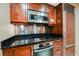 Elegant kitchen with stainless steel appliances, wood cabinets, and dark countertops at 145 Harmon Ave # 1021, Las Vegas, NV 89109