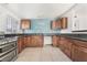 Well-lit kitchen featuring wooden cabinets, tile floors, and updated appliances at 1520 Teton St, Las Vegas, NV 89101