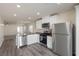 Modern kitchen featuring stainless steel appliances, white cabinets, and sleek countertops open to the living area at 1713 Desert Path Ave, North Las Vegas, NV 89032