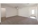 Spacious living room with neutral carpet, ceiling fan, and plenty of natural light from the front door at 1713 Desert Path Ave, North Las Vegas, NV 89032