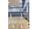 View of the indoor basketball court with hardwood floors, side door access, and adjustable basketball hoops at 172 Tall Ruff Dr, Las Vegas, NV 89148