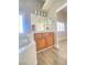 Bathroom with wood cabinets, double sinks, and a large mirror, complemented by modern fixtures and wood-look floors at 172 Tall Ruff Dr, Las Vegas, NV 89148