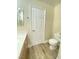 Bathroom with toilet, wood vanity, white countertop and wood-look flooring offering a clean, modern space at 172 Tall Ruff Dr, Las Vegas, NV 89148