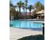 Resort-style community pool with inviting blue water, umbrellas, and palm trees in a beautiful setting at 172 Tall Ruff Dr, Las Vegas, NV 89148