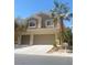 Two story home featuring a tile roof, three car garage, palm tree, and well manicured lawn at 172 Tall Ruff Dr, Las Vegas, NV 89148