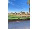 View of the golf course with green grass, water, palm trees and blue sky in the background at 172 Tall Ruff Dr, Las Vegas, NV 89148