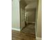 Hallway with hardwood floors leading to a staircase, interior door, and landing area at 172 Tall Ruff Dr, Las Vegas, NV 89148