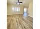 Cozy living room with wood flooring, ceiling fan, and sliding door access to outdoor space at 172 Tall Ruff Dr, Las Vegas, NV 89148