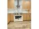A range and range hood featuring marble countertops and a light wood finish at 172 Tall Ruff Dr, Las Vegas, NV 89148