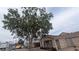 Angle shot of a cozy home with a mature tree providing shade and charm to the facade at 1910 Hoover St, North Las Vegas, NV 89030