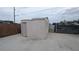 Backyard view of a shed with a concrete foundation and light colored siding on a concrete surface at 1910 Hoover St, North Las Vegas, NV 89030