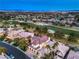 Scenic aerial view featuring a home with a red tile roof, nestled in a community near a green golf course and city skyline at 1912 Glenview Dr, Las Vegas, NV 89134