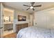 Bright bedroom featuring a ceiling fan, paneled walls, and a stylish en suite bathroom visible through an open doorway at 1912 Glenview Dr, Las Vegas, NV 89134