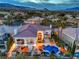 Luxury home featuring a pool, outdoor seating, and a balcony with picturesque mountain views at dusk at 1912 Glenview Dr, Las Vegas, NV 89134