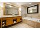 Bright bathroom featuring double vanity, soaking tub, and neutral toned stone floors at 2000 Fashion Show Dr # 2604, Las Vegas, NV 89109