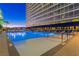 Outdoor pool with lounge chairs, palm trees, and an illuminated tower at 2000 Fashion Show Dr # 2604, Las Vegas, NV 89109