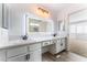 Bright bathroom featuring double sinks, sleek white cabinetry, illuminated mirror, and modern finishes at 2222 Little River Ct, Las Vegas, NV 89156