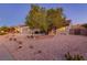 A well-manicured front yard with desert landscaping, complete with a mature shade tree and a wide driveway at 2341 Rosendale Village Ave, Henderson, NV 89052