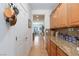 Hallway leading to open kitchen, highlighting granite countertops and wooden cabinetry at 2341 Rosendale Village Ave, Henderson, NV 89052