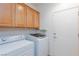 Bright laundry room with overhead cabinets and modern washer and dryer at 2341 Rosendale Village Ave, Henderson, NV 89052