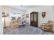 Cozy living room featuring carpeted floors, a beige sofa, and an elegant armoire at 2341 Rosendale Village Ave, Henderson, NV 89052