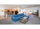 Open-concept living room with a blue sectional sofa, seamlessly connecting to the kitchen and dining areas at 2341 Rosendale Village Ave, Henderson, NV 89052