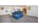 Comfortable living room features a large blue sofa, seamlessly connected to the kitchen and dining area at 2341 Rosendale Village Ave, Henderson, NV 89052