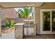 A built-in outdoor kitchen featuring a stainless steel grill and stone accents, perfect for outdoor cooking at 2341 Rosendale Village Ave, Henderson, NV 89052