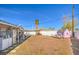 Backyard with desert landscape, covered patio, perimeter fence, and a playhouse at 2450 Tournament St, Las Vegas, NV 89142